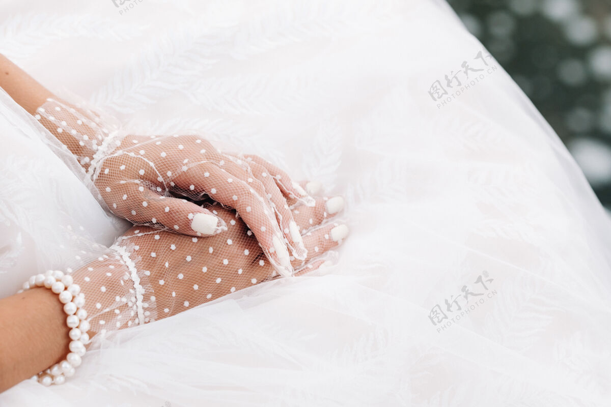 手套在公园瀑布附近 新娘戴着白色透明手套的手的特写镜头年轻女人爱情