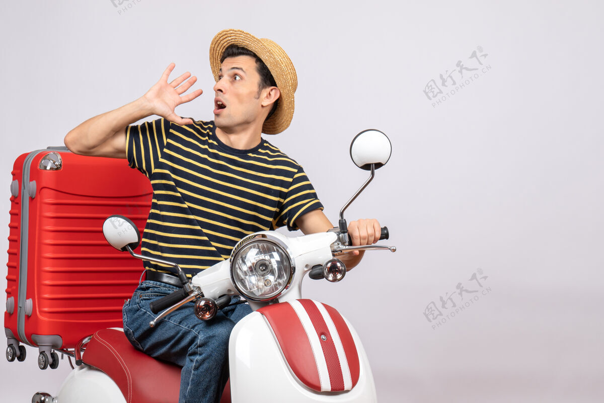 轻便摩托车一个戴着草帽的年轻人的正面照片坐着前面传送带