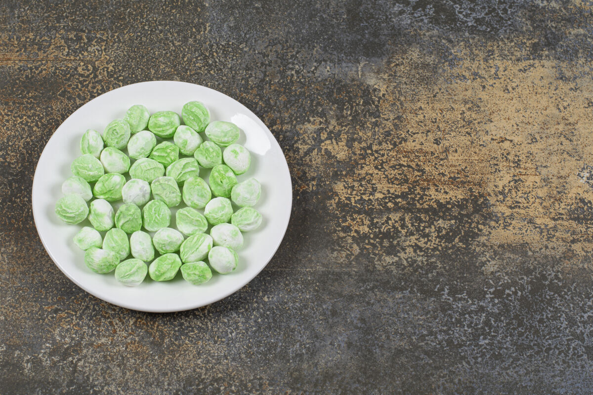 薄荷白色盘子上的绿色薄荷醇糖果邦邦糖果薄荷