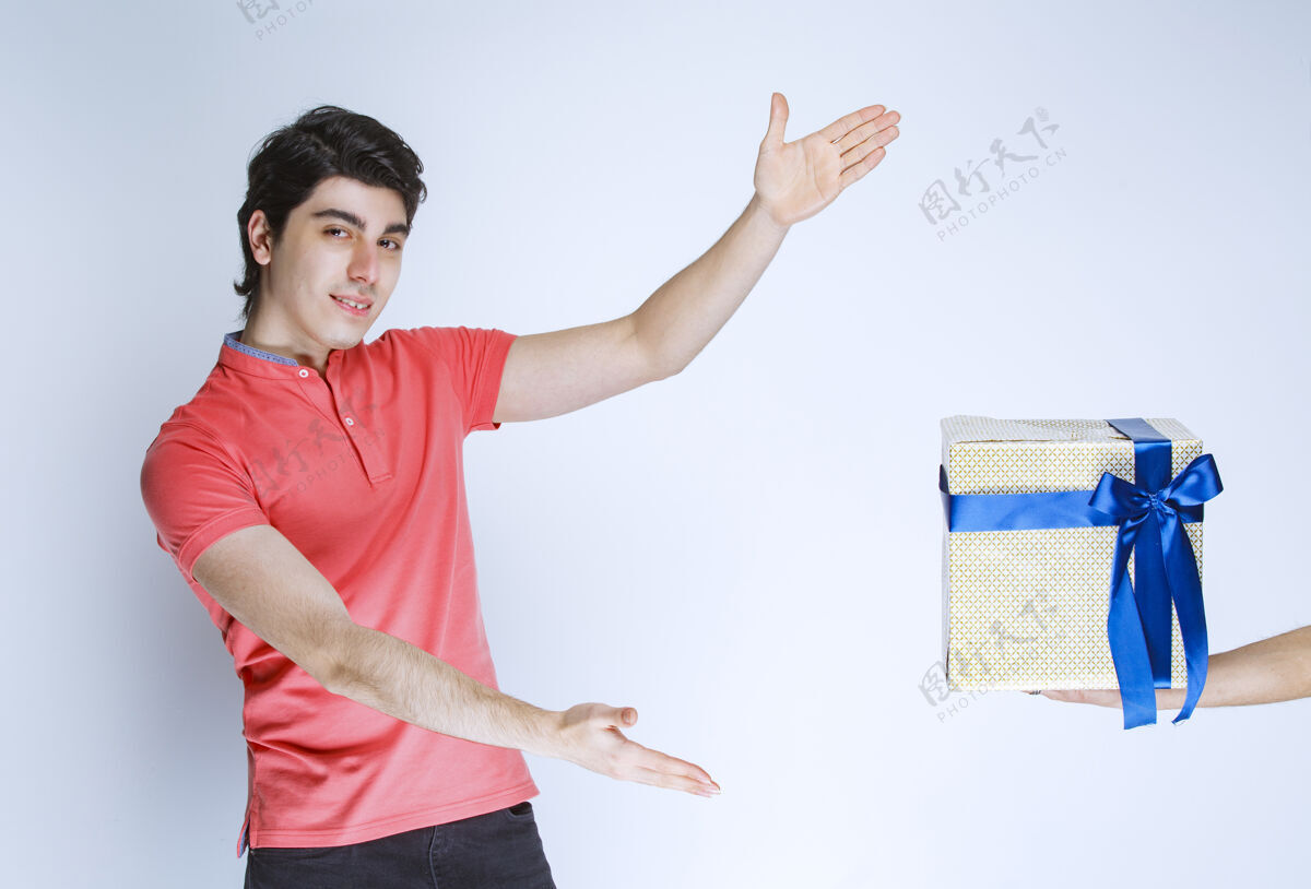 工人一个男人双手拿着一个包着蓝丝带的白色礼盒紧身衣姿势人