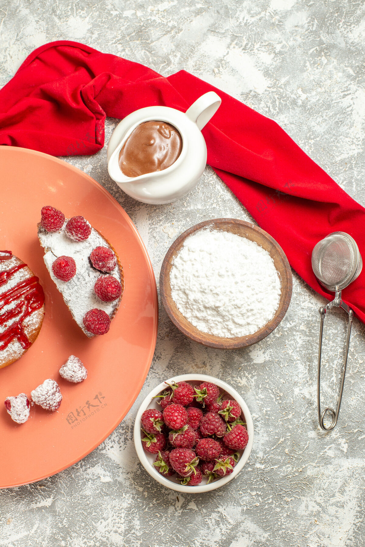 餐巾一盘甜点的俯视图 旁边是大理石背景上的巧克力茶筛浆果和红色餐巾背景餐厅浆果