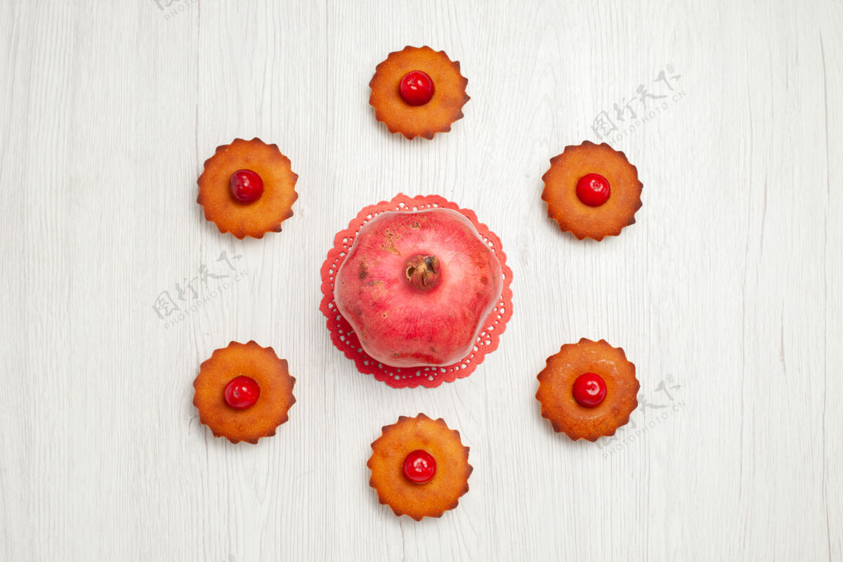 甜点俯瞰白色地板上美味的小蛋糕饼干春天雏菊