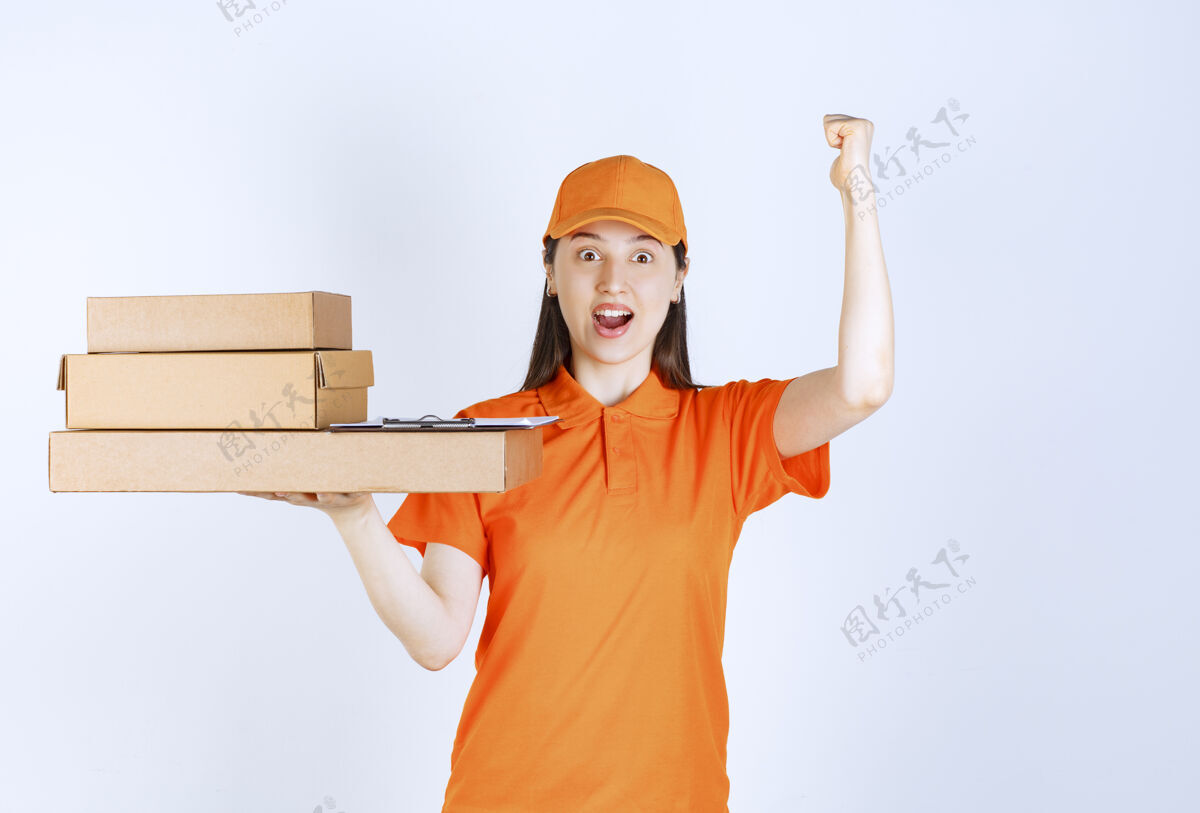 服务身着橙色制服的女服务人员 提供多个纸板箱 并显示正面手势动力动力快乐