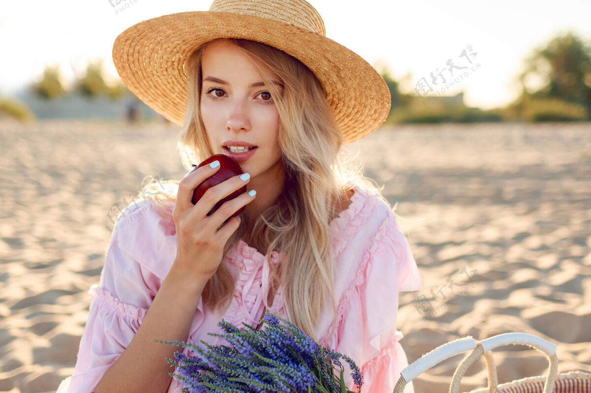 休息戴草帽的自然白人女孩在海边享受周末的特写照片与水果合影草包里有一束薰衣草海滩脸水果