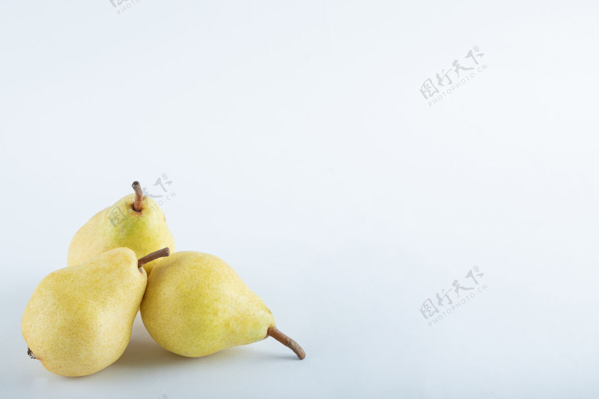丰收三个黄色的梨子在白色的上面梨农业熟