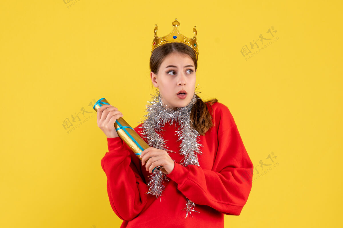 复制前视图穿着红色毛衣和皇冠的年轻女孩举行派对波普波普尔派对脸