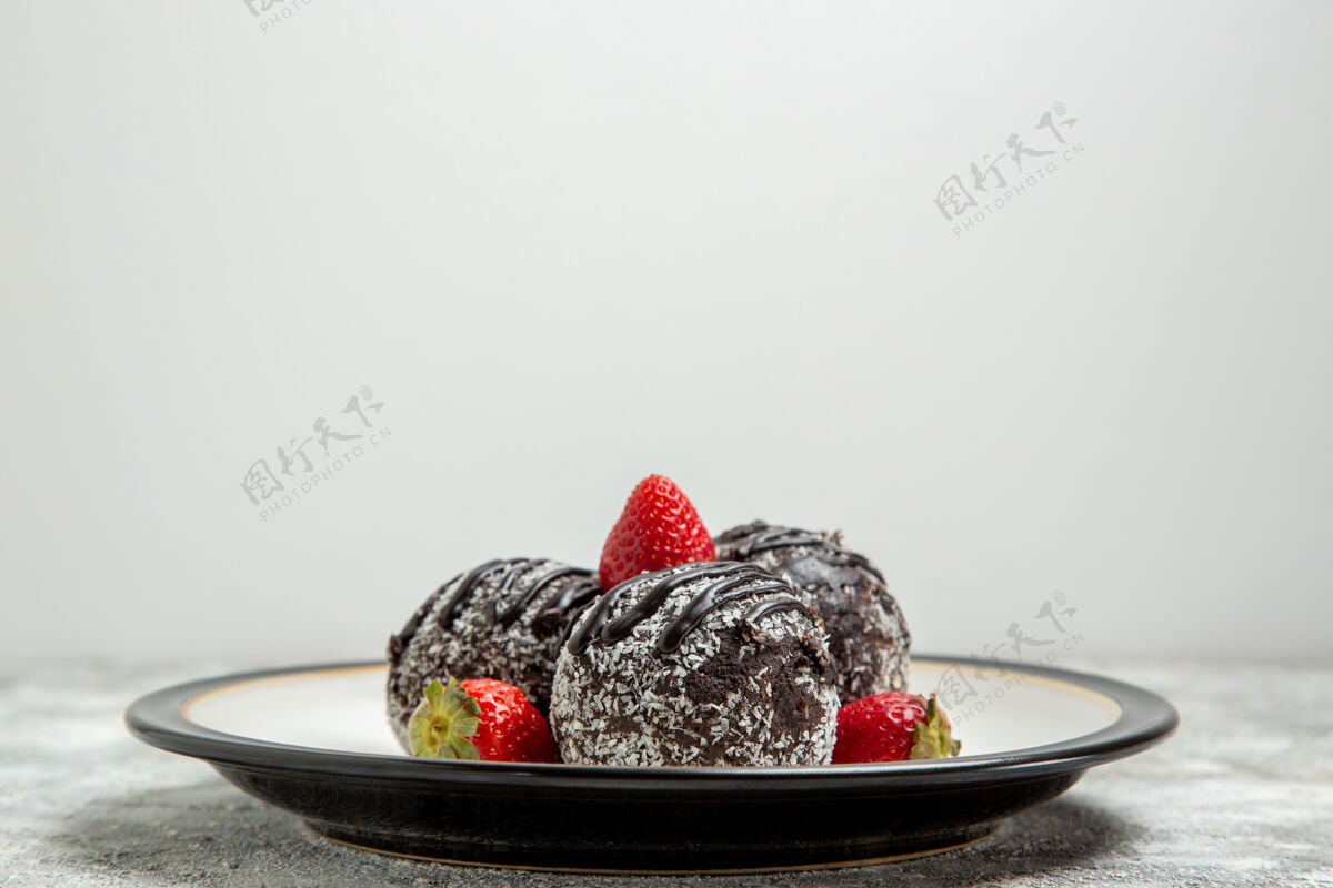 草莓正面图美味的巧克力蛋糕和新鲜的红草莓在浅白色的表面巧克力糖饼干甜蛋糕烤饼干视野生的甜点