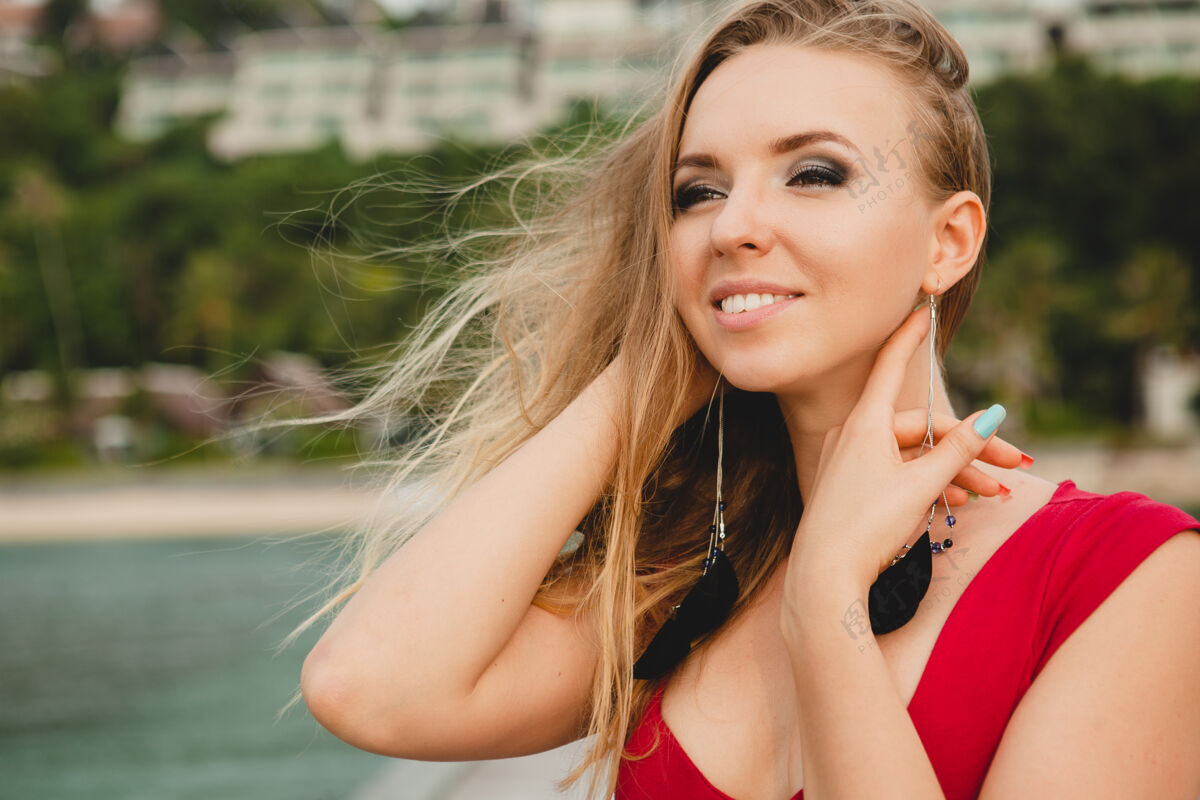 女性年轻漂亮迷人的女人独自站在豪华度假酒店的码头上 暑假 红色长裙 金色头发 性感服装 热带沙滩 诱惑 性感 微笑奢华热带模特