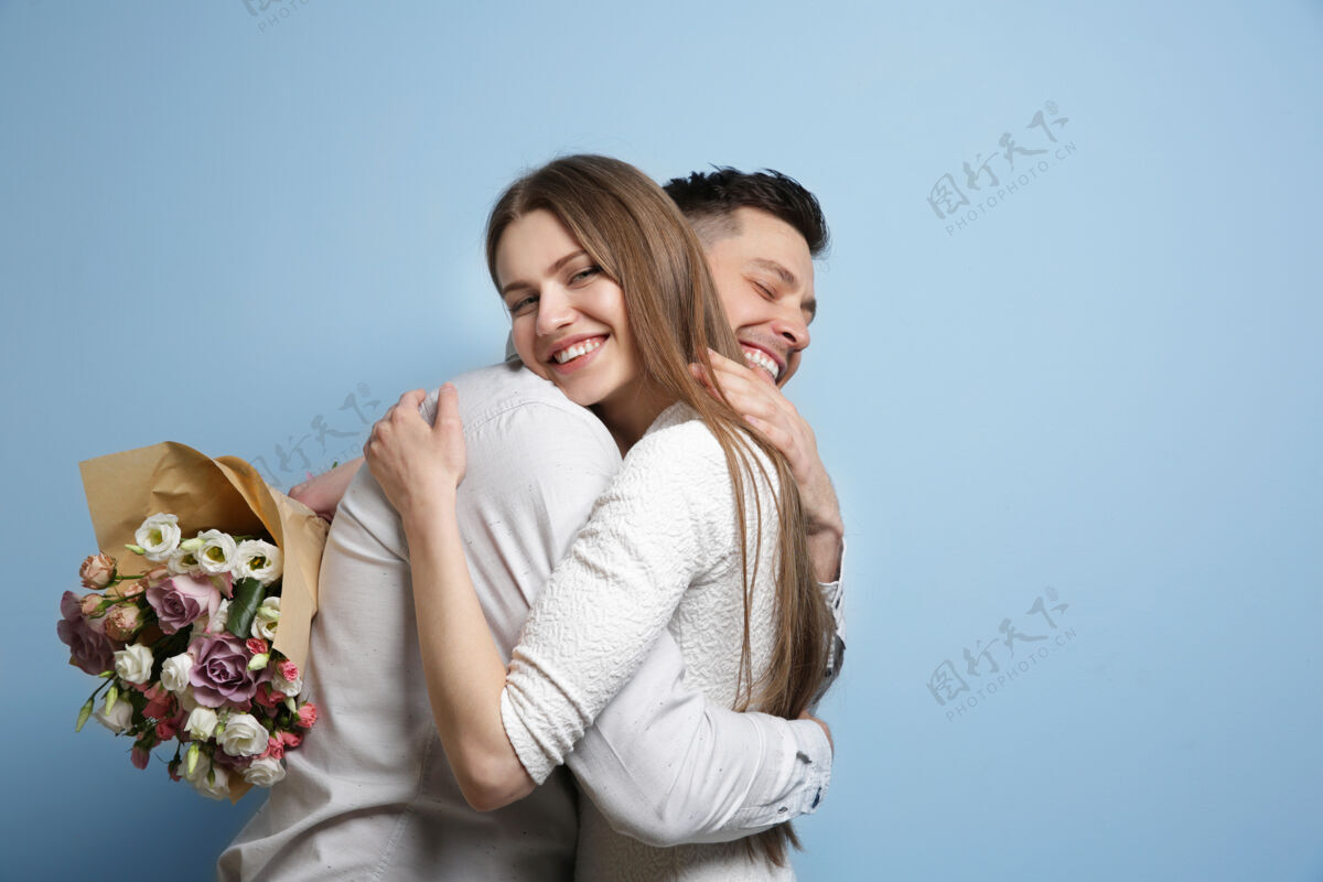 礼物一对幸福的年轻夫妇 在灯光下放着一束鲜花休闲玫瑰光