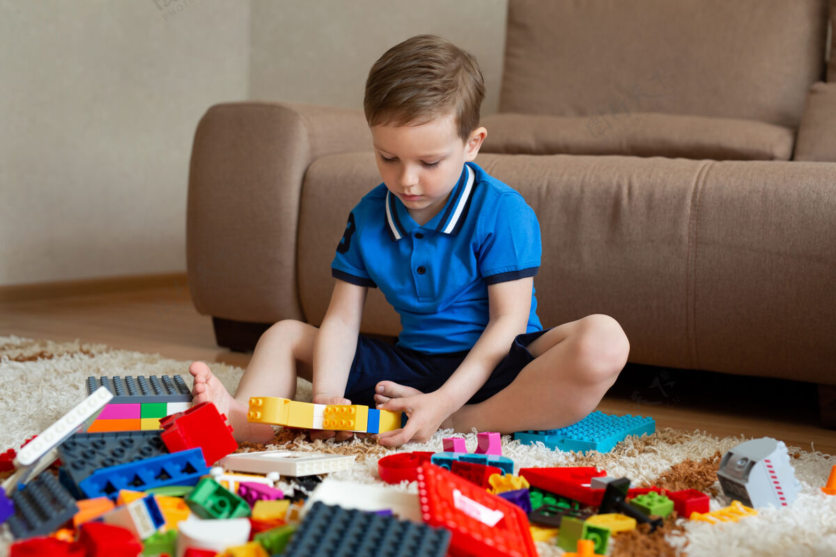 童年小男孩在地板上玩建筑工具立方体学习教育