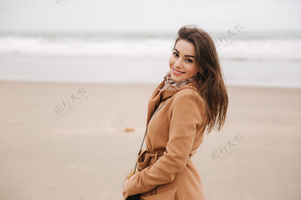女人美丽女子在北海沿岸散步的肖像穿着棕色外套的优雅女士海滩微笑成年人