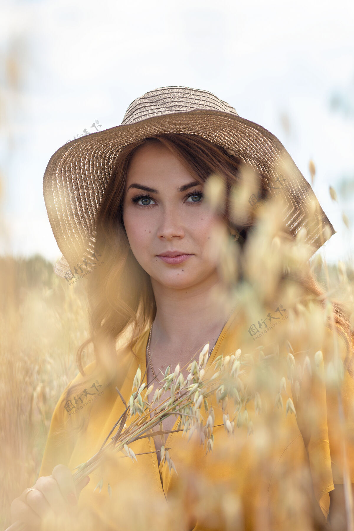 农村在一个阳光明媚的夏日 一位年轻漂亮的孕妇穿着黄色的裙子 戴着黄色的帽子 走过一片麦田肥料母亲肖像
