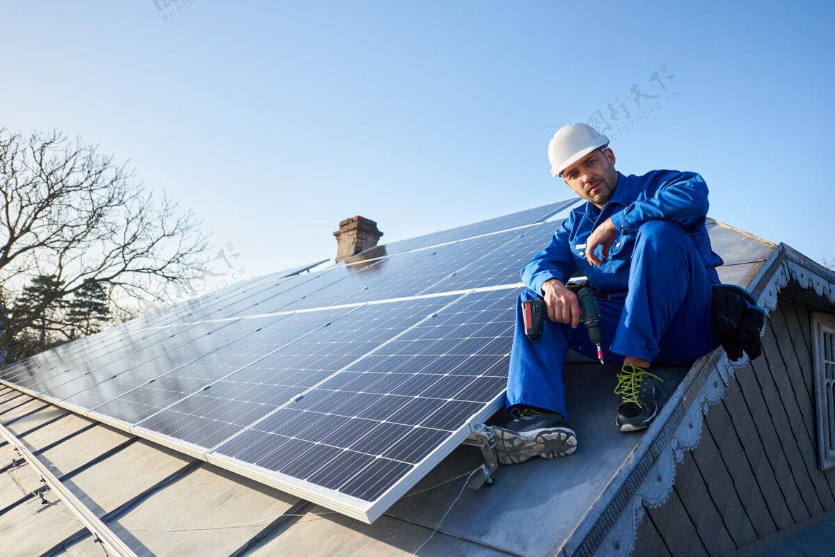 生态电工在现代住宅的屋顶上安装太阳能板工人发电技术人员