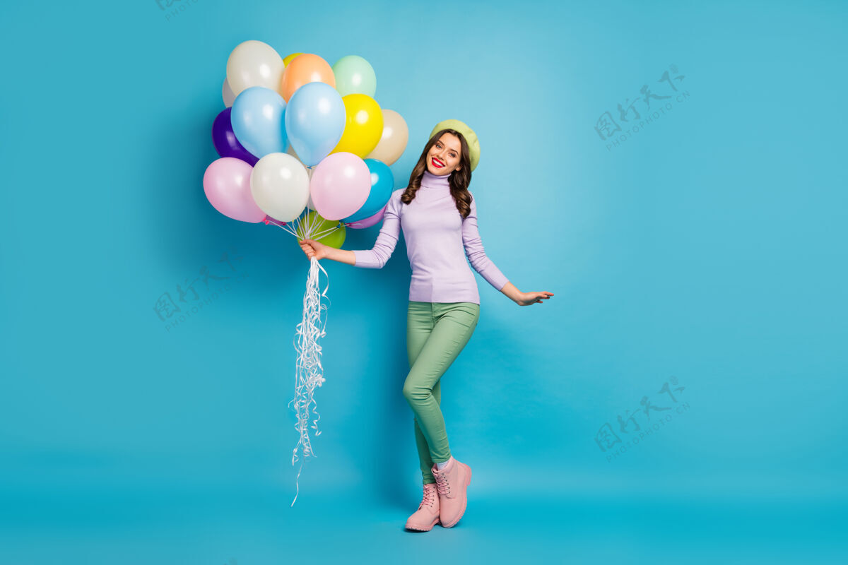 娱乐整幅搞笑美女照片带来许多五颜六色的气球朋友活动派对穿紫色毛衣贝雷帽绿色裤子鞋蓝色隔离墙模特黑发时髦