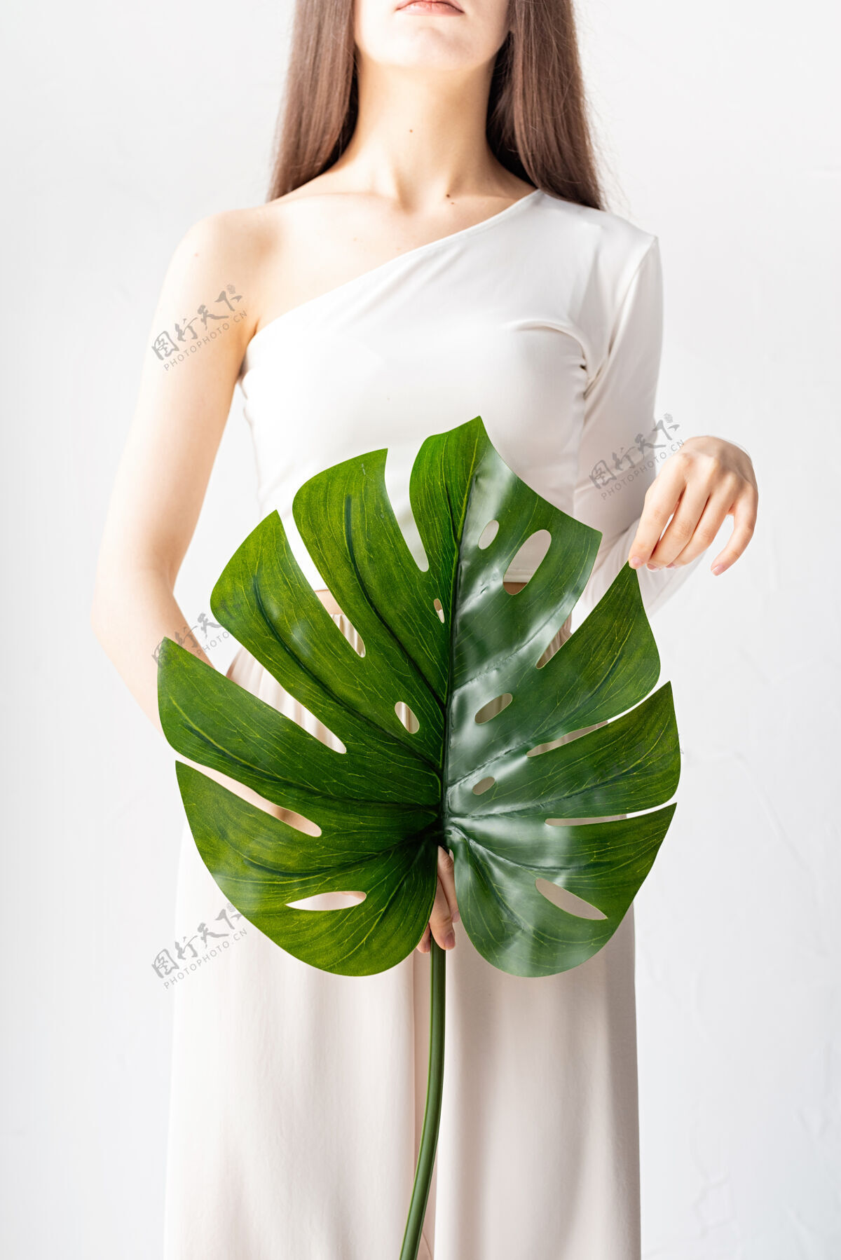 叶子水疗和美容自我护理和皮肤护理一个穿着舒适衣服 手持绿叶的快乐美女怪物女孩女性