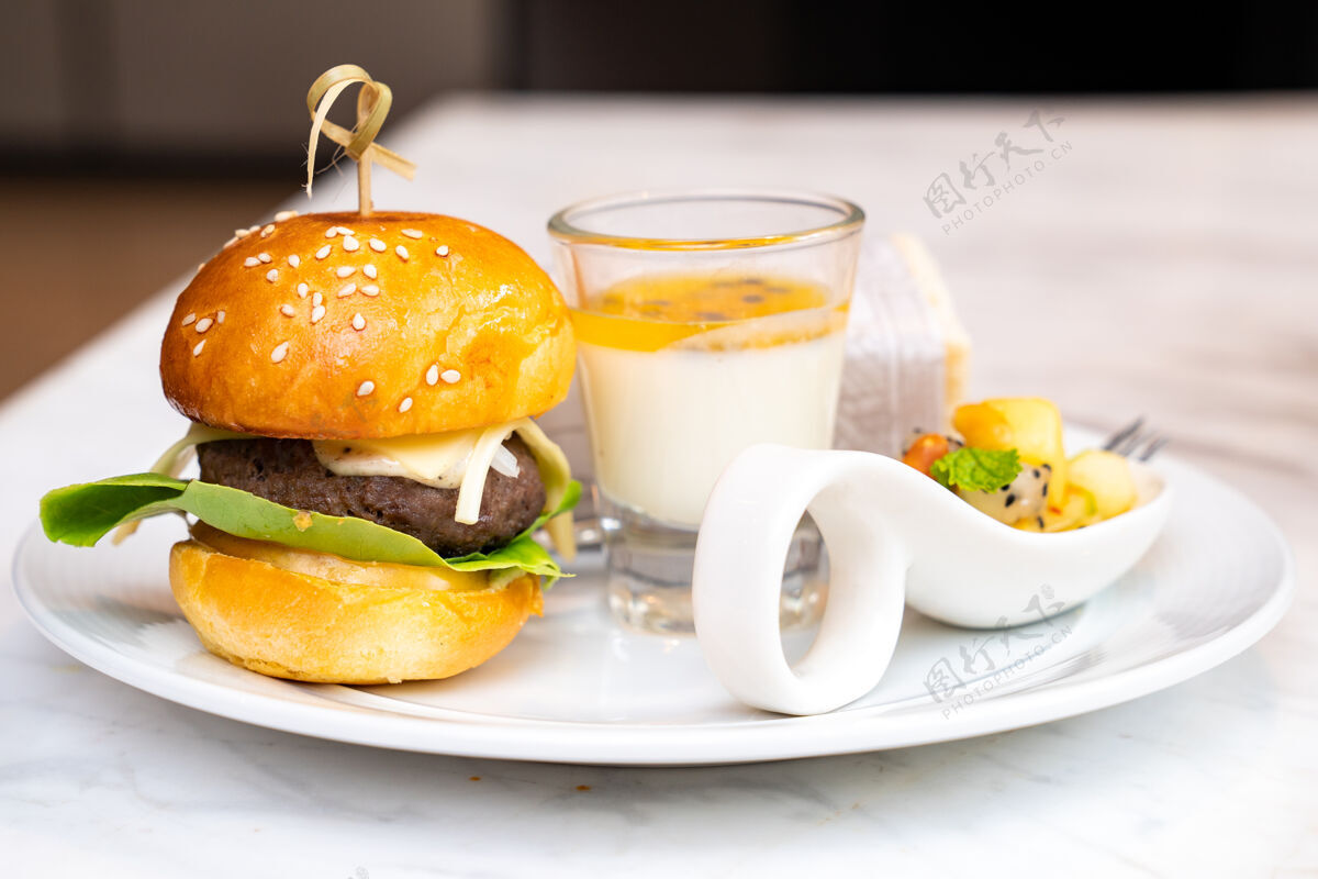 杯子小汉堡包和西番莲布丁在玻璃与混合水果和包装沙德维什设置在白色菜肴的酝酿时间快餐汉堡休息