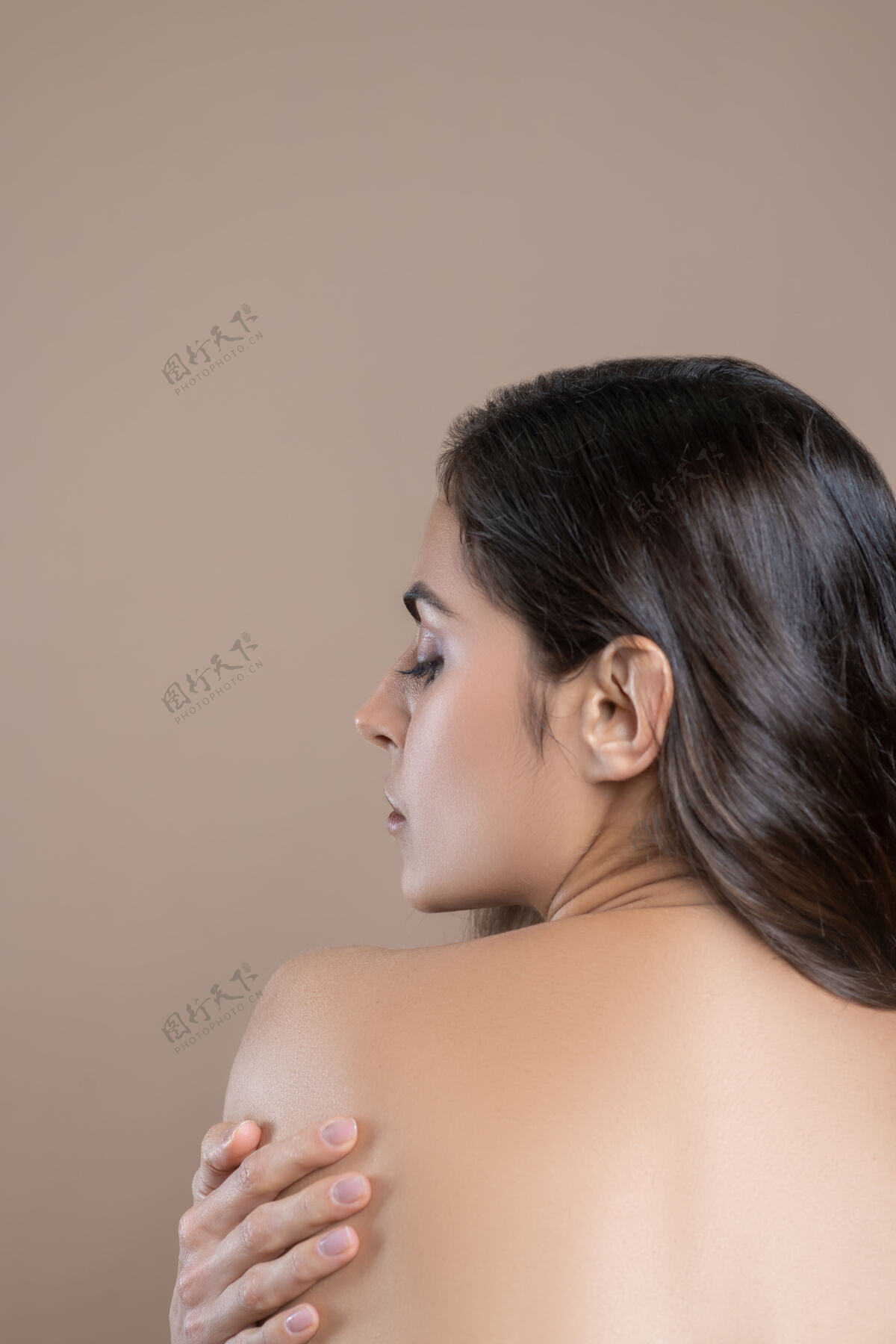 沉思温柔的触摸深色-一个头发花白的漂亮女人 背上用手托着肩膀 脸对着镜头皮肤护理温柔裸体