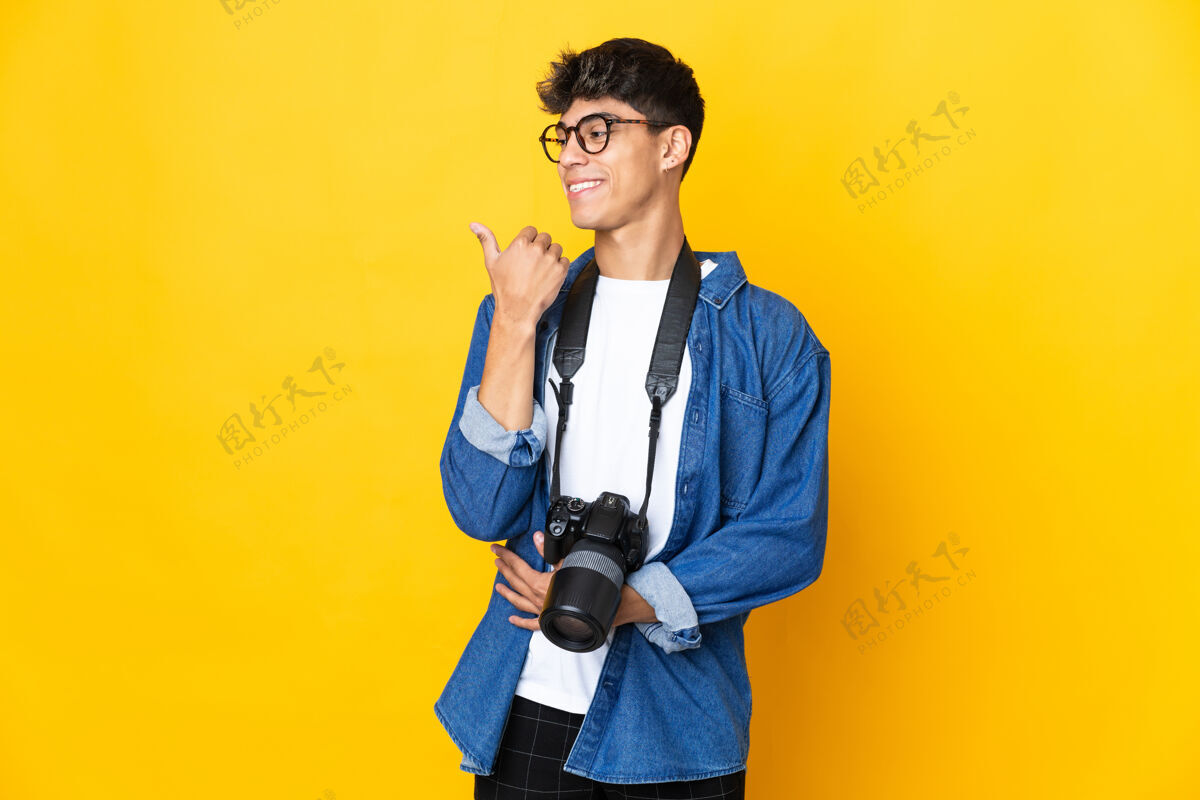 人年轻的摄影师越过隔离的黄色墙壁指着旁边的人介绍一个产品指向微笑点