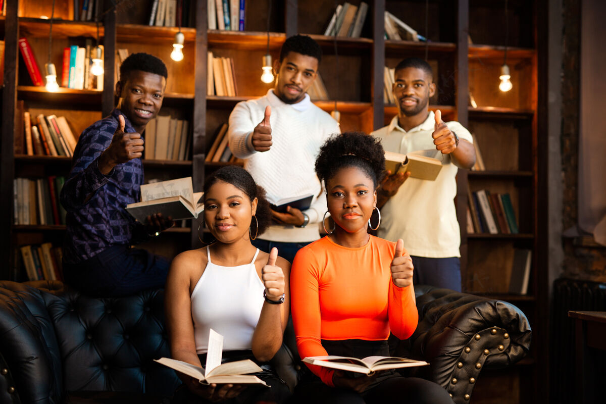 大学美丽的非洲年轻人拿着书在图书馆里用手势学校休闲大学