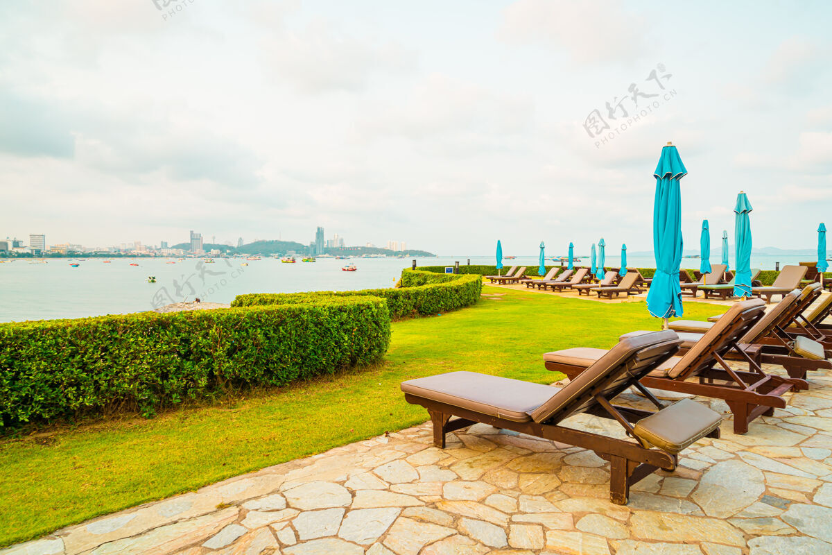马尔代夫泰国芭堤雅海滩游泳池周围的椅子游泳池或床游泳池和伞休闲豪华旅游