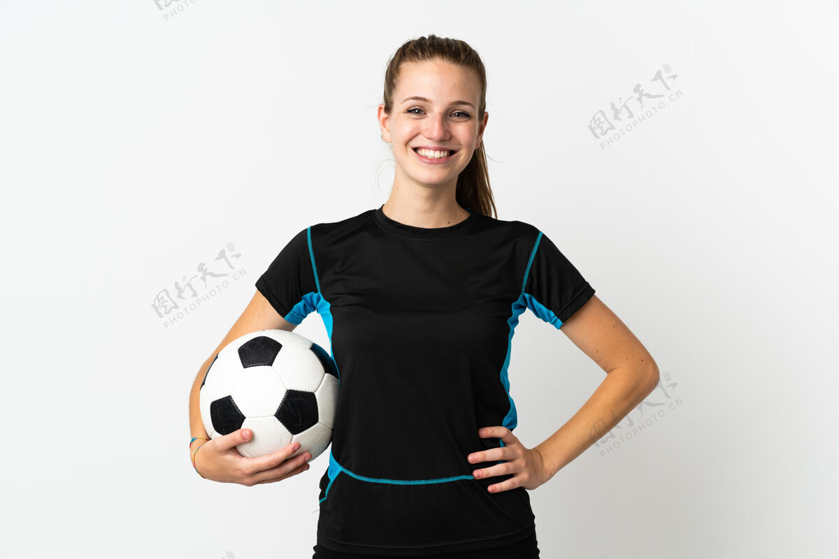 成人一个年轻的足球运动员 一个在白色背景下孤立的女人 双臂放在臀部 面带微笑比赛年轻骄傲