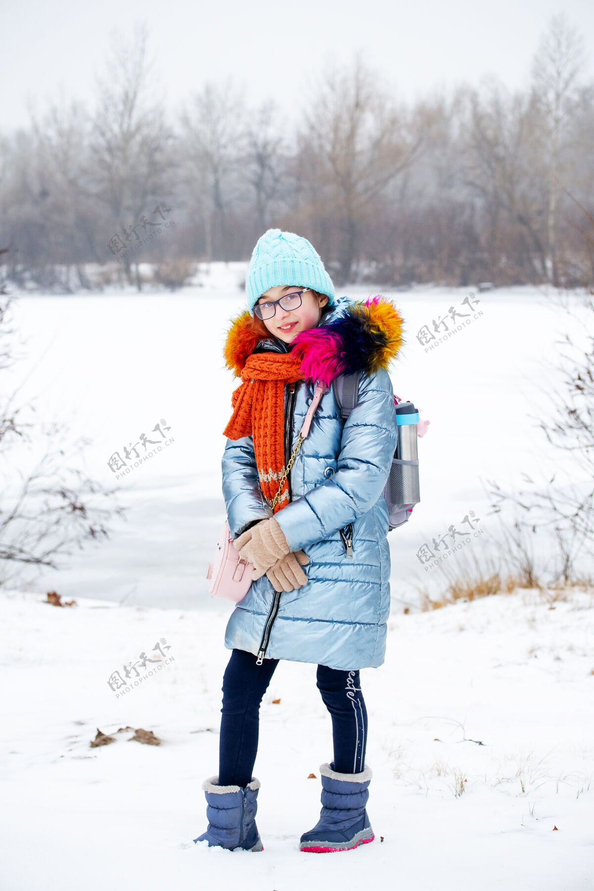 女人冬日少女的画像在她的温暖服装.青少年下雪天戴蓝帽子的可爱女孩帽子下雪天气