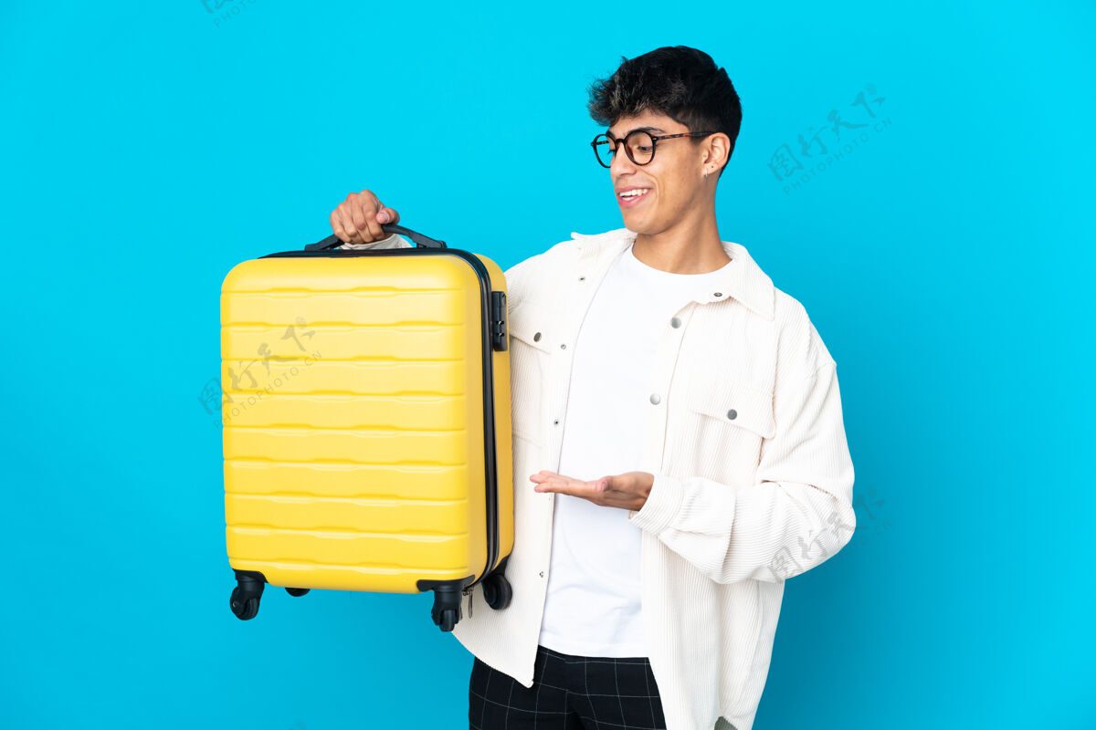行李带着旅行箱的年轻人在度假时越过了与世隔绝的蓝色背景减肥旅行行李