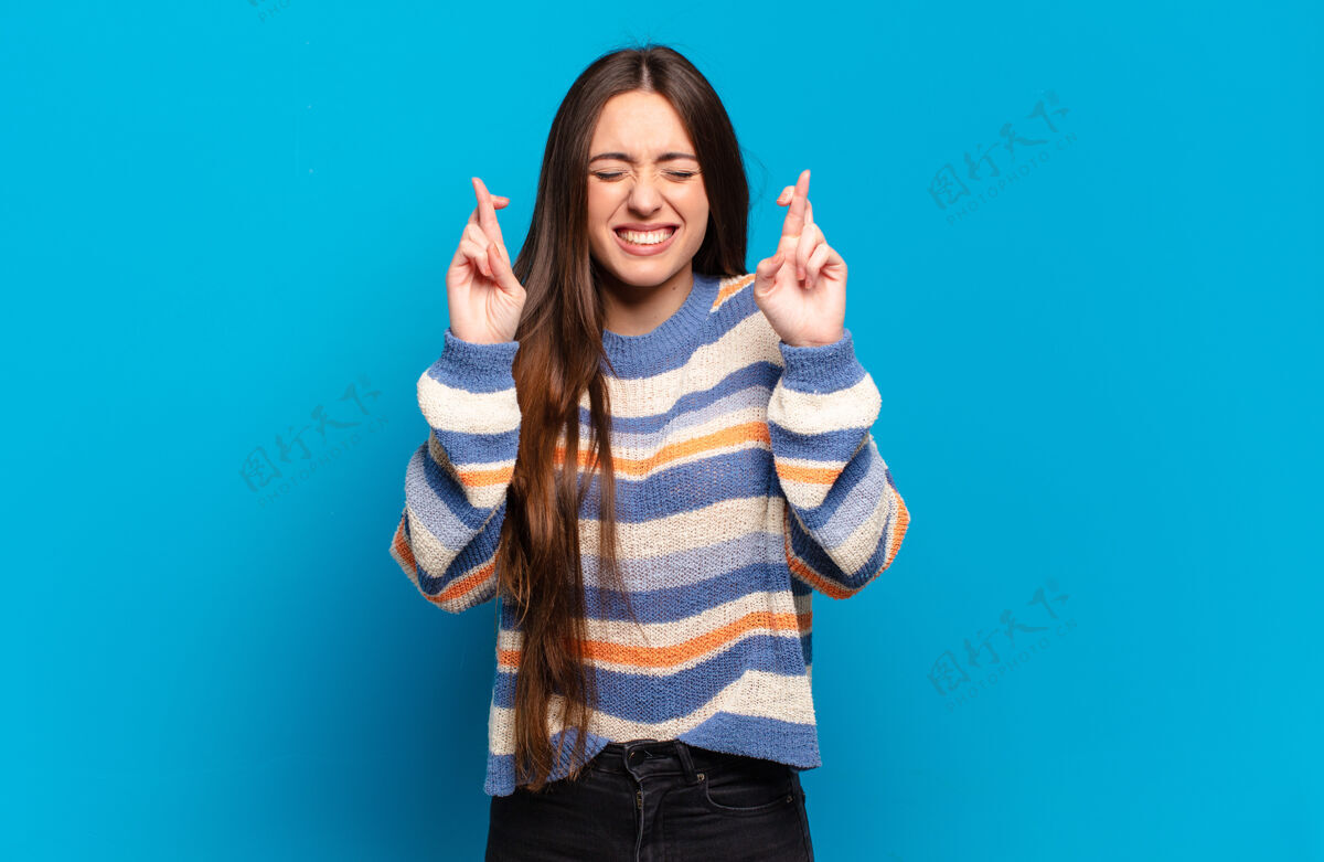 发型年轻漂亮随意的女人感到紧张和希望 交叉手指 祈祷和希望好运漂亮成人优雅