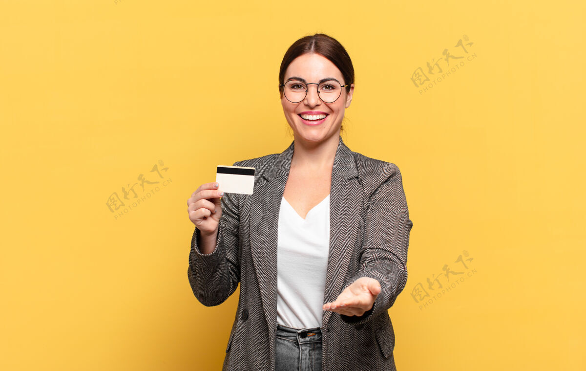 支付年轻漂亮的女人微笑愉快 友好 自信 积极的样子 提供和显示一个对象或概念指标卡银行