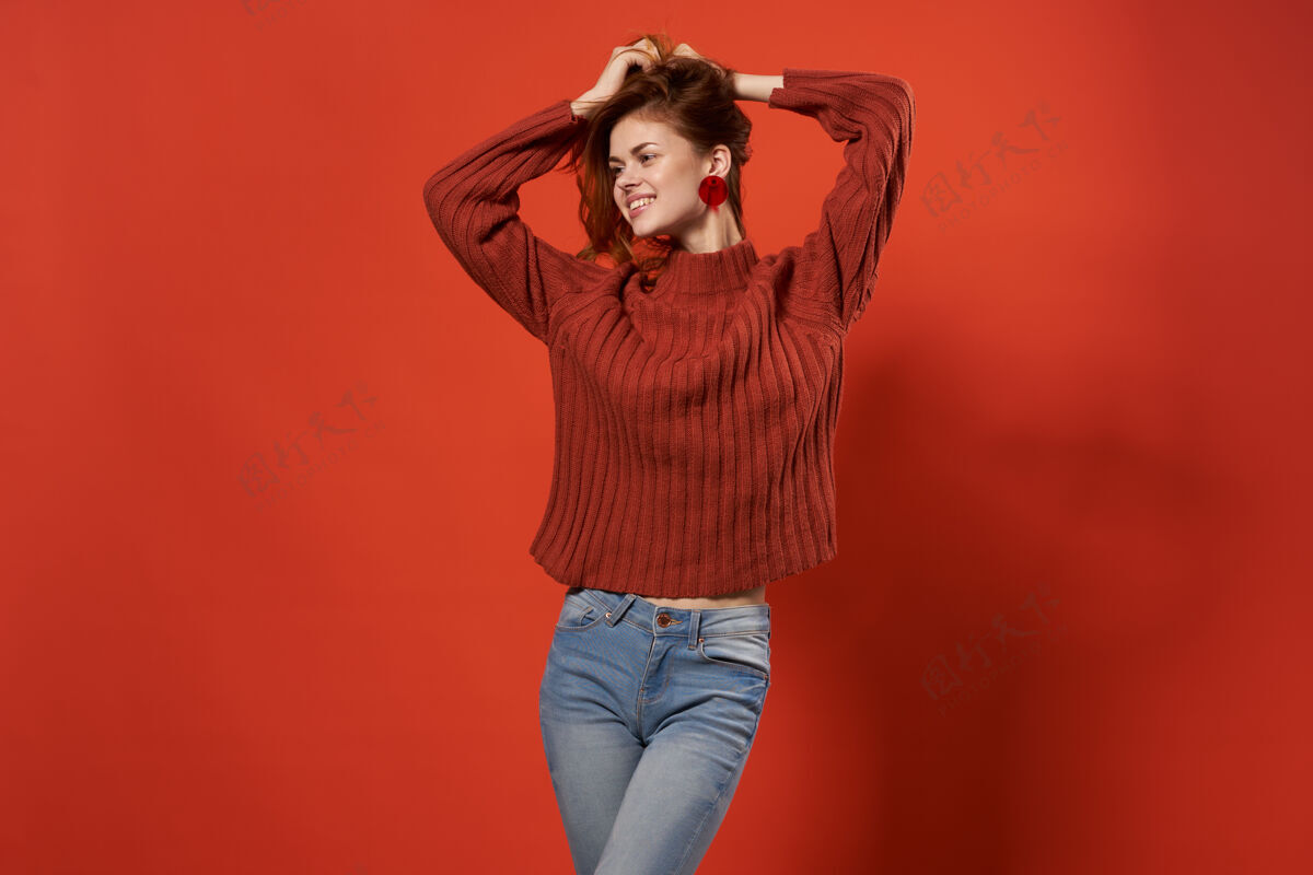 新鲜情绪化的女人穿着红色毛衣拿着工作室装饰的红头发身体健康漂亮
