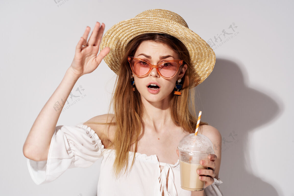 年轻美女戴着时尚的眼镜和帽子装饰魅力饮品模特欢呼办公室茶