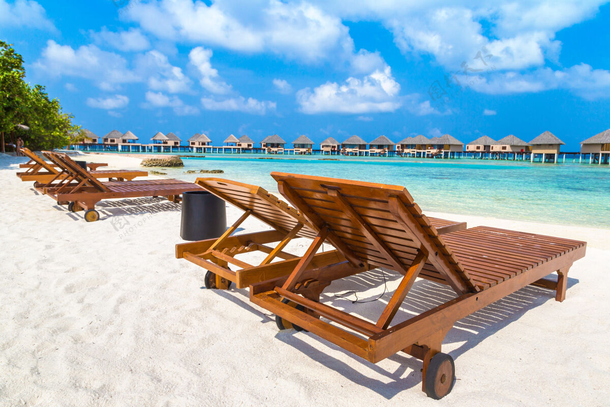 度假马尔代夫热带海滩上的木制日光浴床旅游海洋椅子