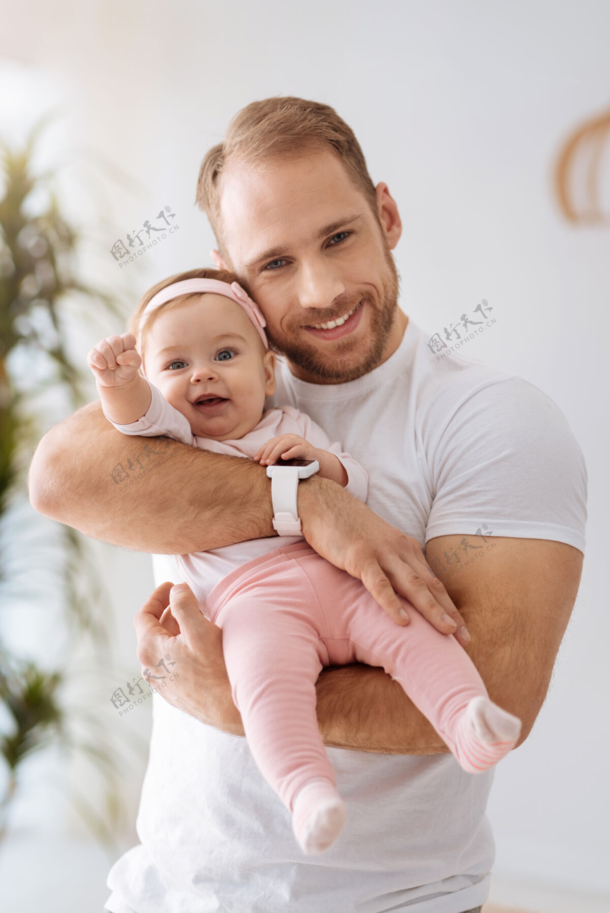 发展探索一切周围有趣可爱快乐的女婴躺在爸爸的手里 一边看着别处 一边表达着兴趣和喜悦为人父母房子世代
