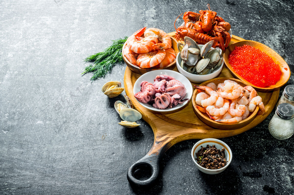 蟹海鲜.虾 小龙虾 牡蛎 章鱼和鱼子酱放在砧板上的碗里美食晚餐甲壳类动物