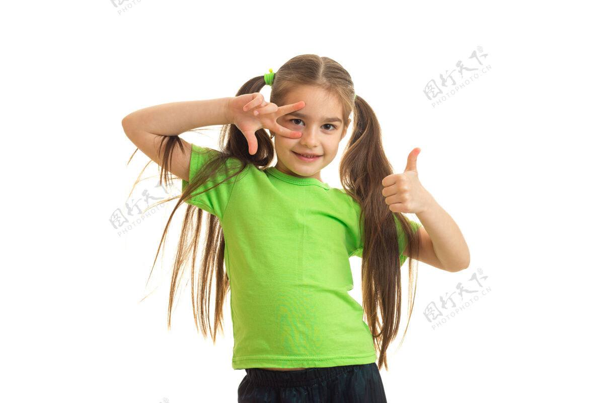 青少年滑稽的小女人竖起大拇指 微笑着站在白色的地板上足球年轻人乐趣