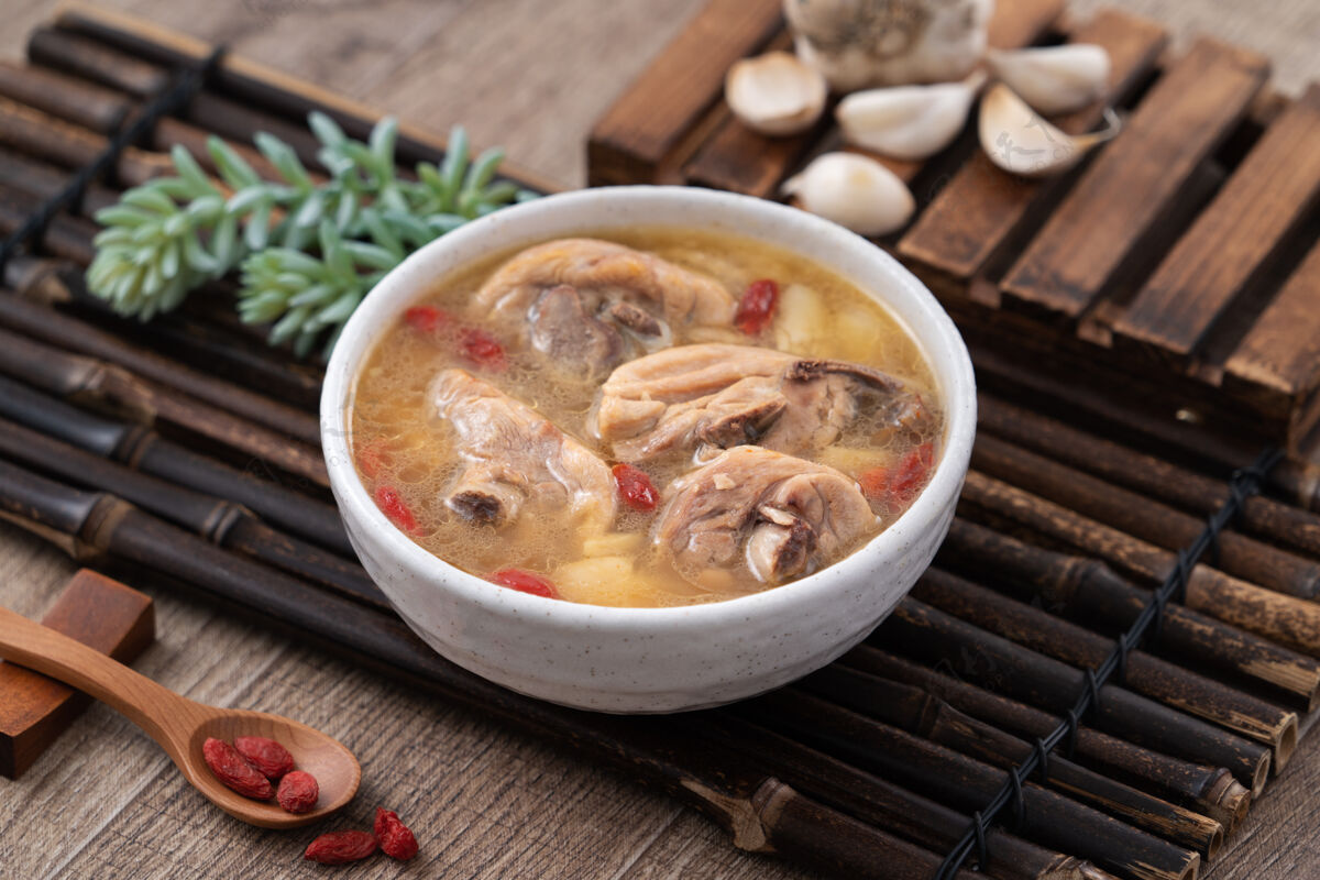 桌子台湾菜-自制美味的蒜味鸡汤放在一个碗里 背景是深色的木桌健康传统锅
