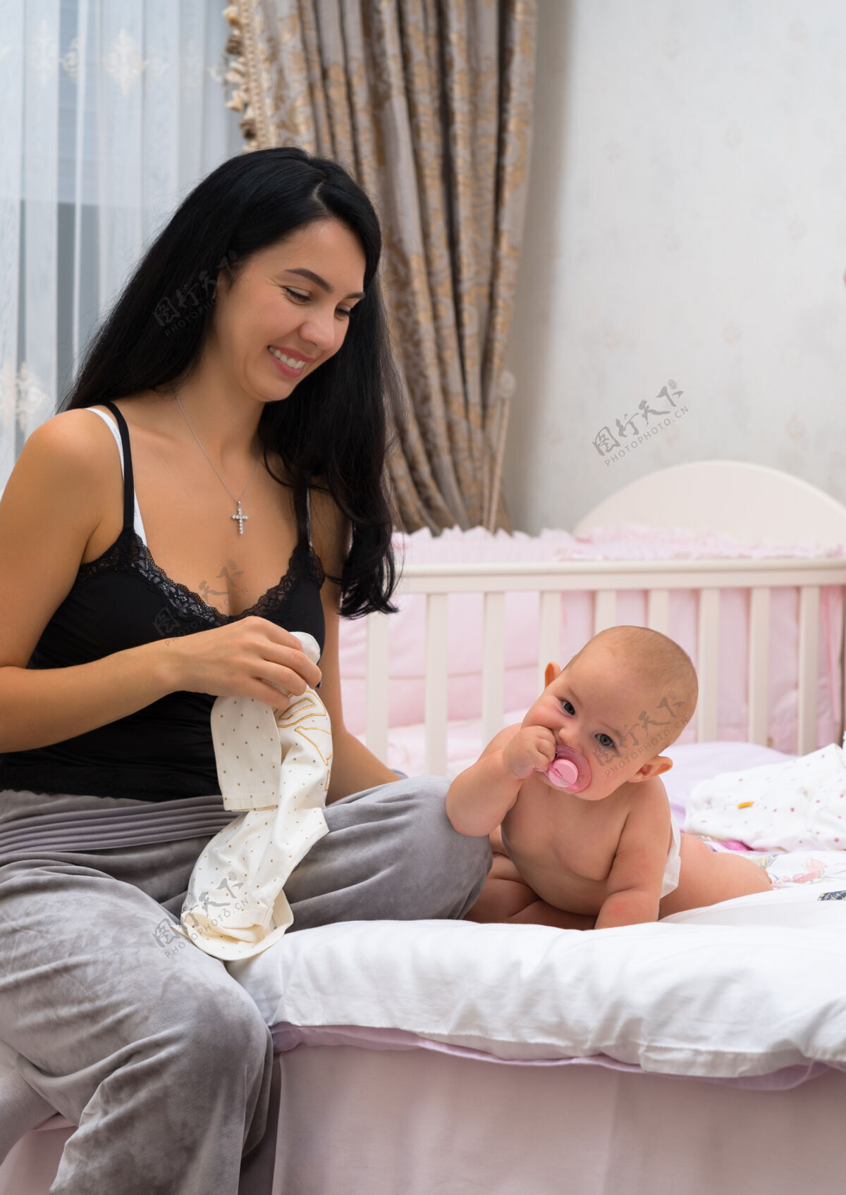 房子一个微笑的年轻妈妈和她快乐的宝宝在粉色卧室里的场景床关系小