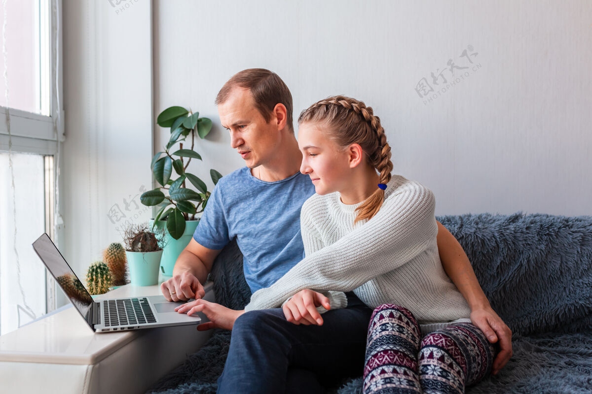 电子小玩意父女俩用笔记本电脑与爷爷奶奶进行视频通话留守在家 远程沟通的理念教育女儿距离