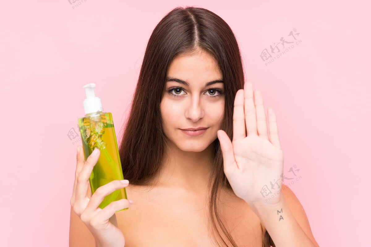 芦荟年轻的白种女人拿着芦荟保湿霜站着 伸出的手显示停止标志 阻止你拒绝化妆品警告