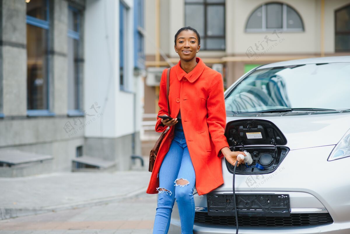 街道美国女孩在加油站给电动汽车充电清洁汽车信心