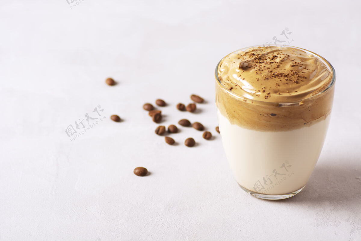 时尚达尔戈纳咖啡架在灰色水泥桌上的玻璃杯里 旁边是咖啡豆美味甜味饮料