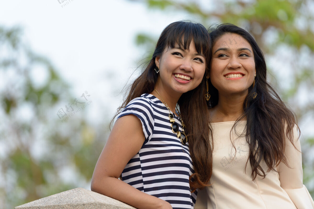 放松两位亚洲年轻女性在公园户外放松的写真东南一起浪漫