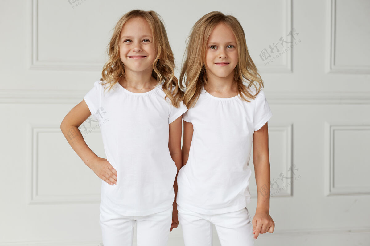 可爱两个穿着白衣服微笑的小女孩工作室快乐孩子