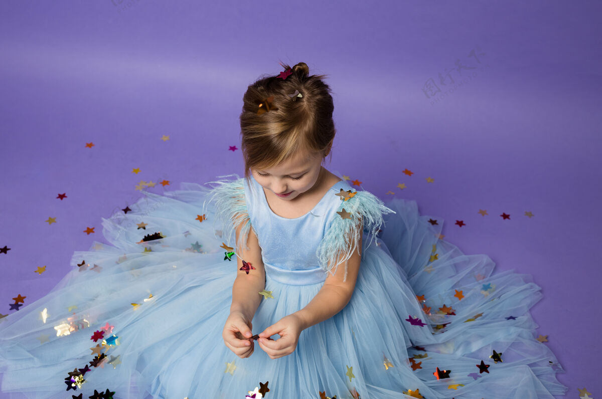 宝贝穿公主装的小女孩在玩紫色的五彩纸屑公主连衣裙有趣化妆舞会