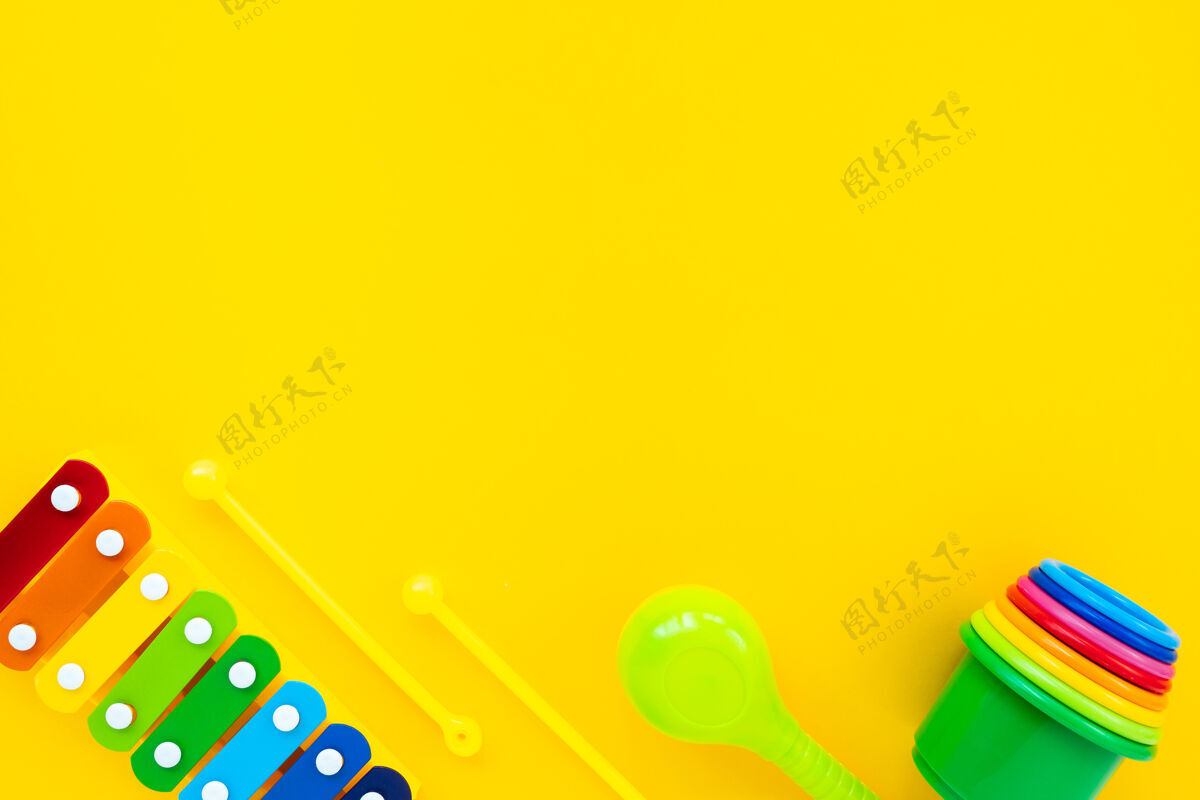 塑料明亮的彩虹儿童木琴和金字塔的黄色背景顶视图配件无人