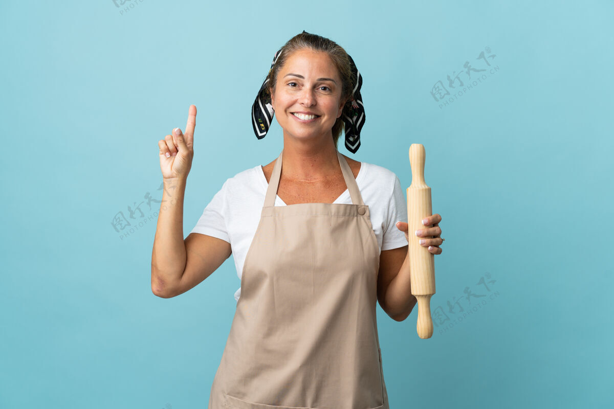 围裙穿着厨师制服的中年妇女指着一个好主意烹饪别针女