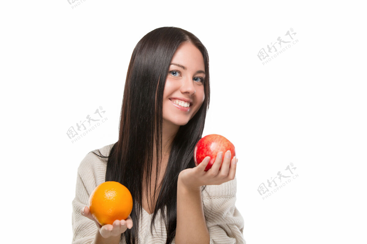漂亮女孩选择苹果和橘子隔离在白色女性异国情调切割