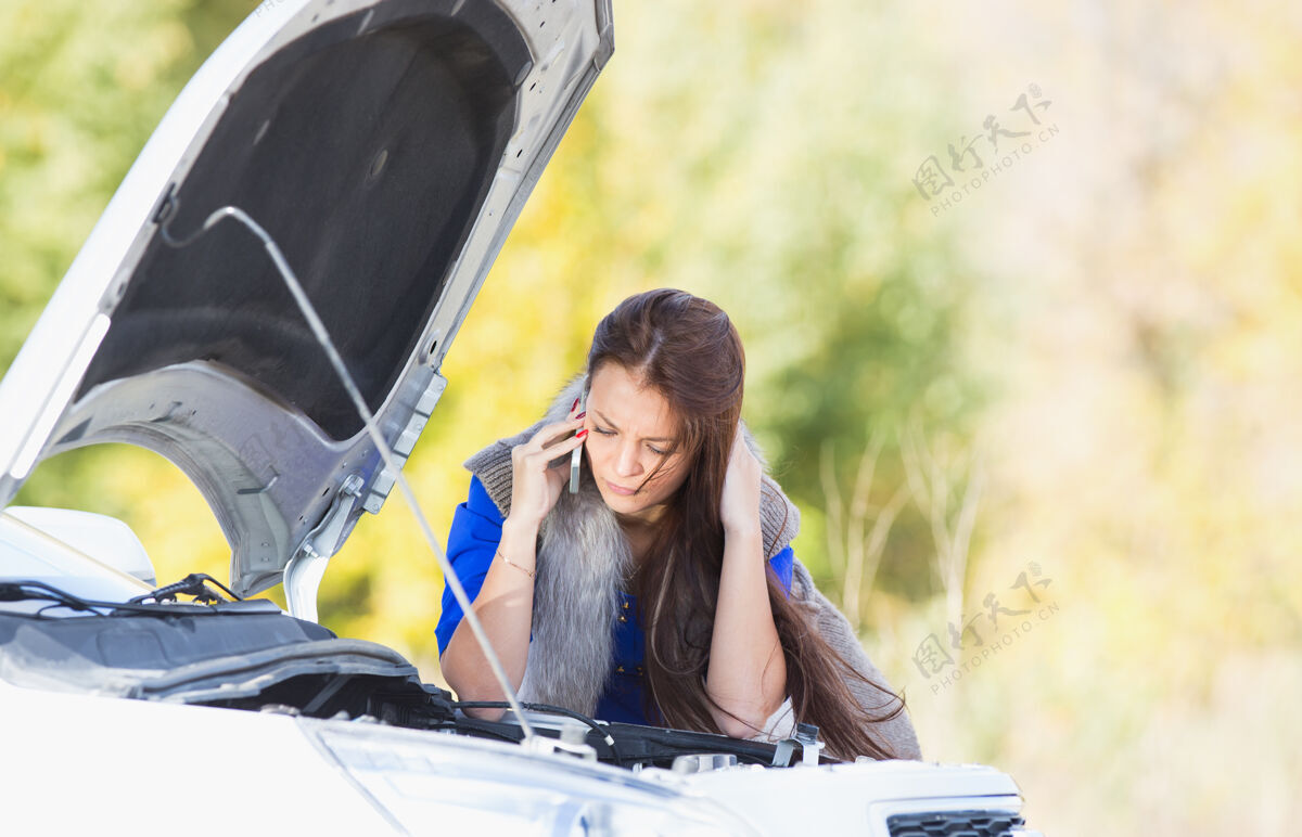 绝望一个女人开着引擎盖在一辆坏了的车里打电话电话女人机器