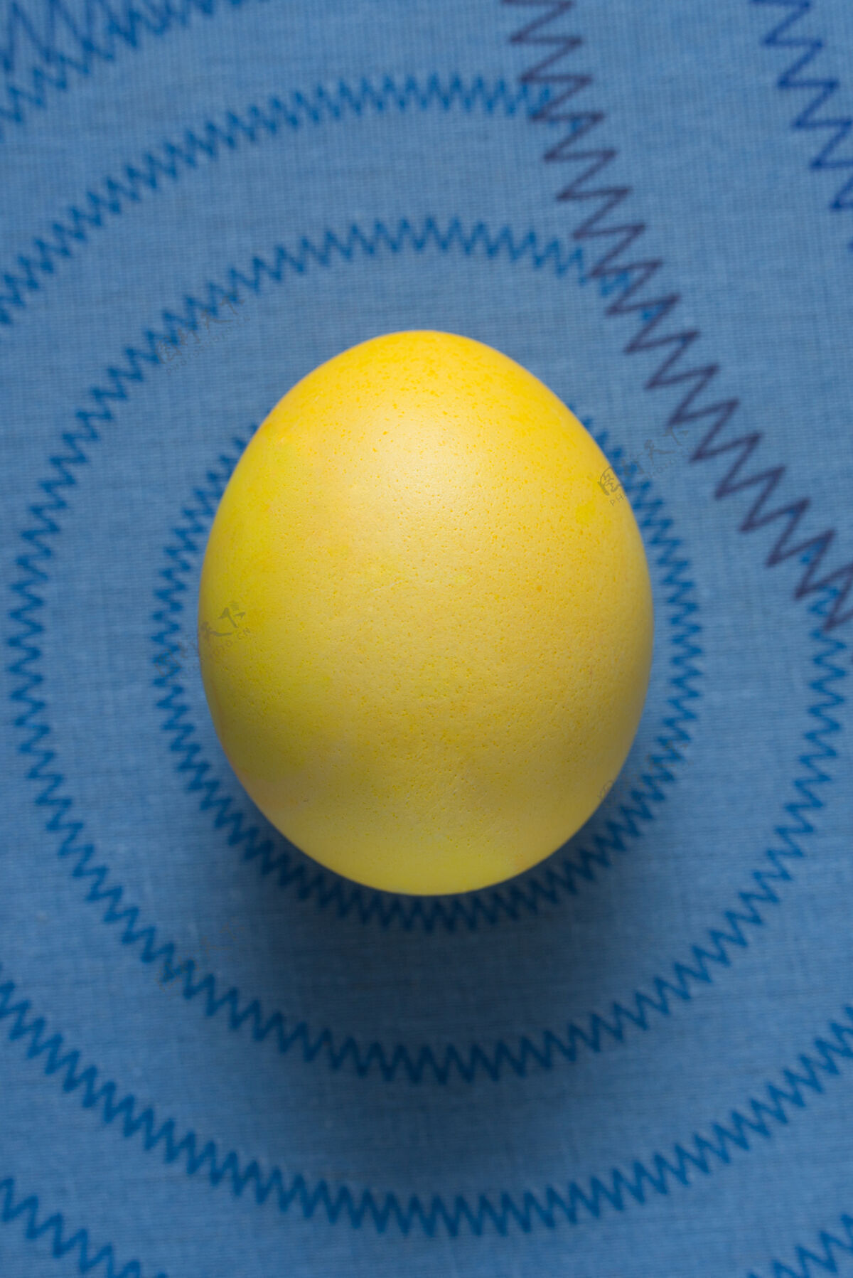 饮食蓝色表面上的黄色复活节彩蛋生禽类配料