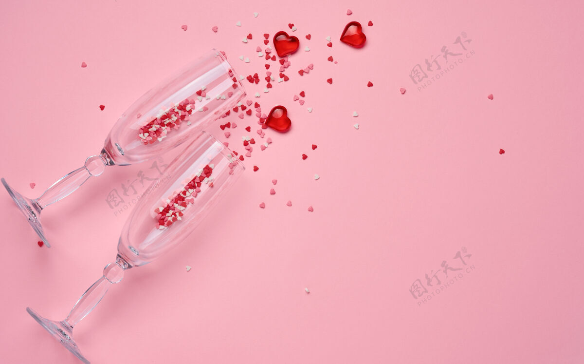 场合两个香槟酒杯 红色心形五彩纸屑和装饰性的心形在粉红色上飞溅背景情人节礼物天概念.top查看 复制空间葡萄酒干杯金色